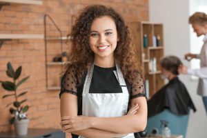 Portrait of a Hairdresser in a Beauty Salon with Client and Fellow Hairdresser Blurred in the Distance with Business Insurance in Charlotte, NC