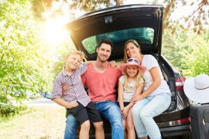 Family Smiling, Sitting for Photo in Back of Car's Trunk with Affordable Auto Insurance in York, SC