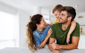 Family Laughing and Smiling in Living Room of Home with House Insurance in Gastonia, NC