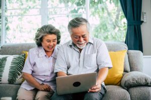 a couple laughing using a laptop with Home Insurance in Belmont, NC, Charlotte, Columbia, SC, Gastonia, Rock Hill, SC, Shelby, NC