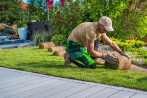Landscaper installing sod with his equipment covered by Landscaper Insurance in Rock Hill, SC